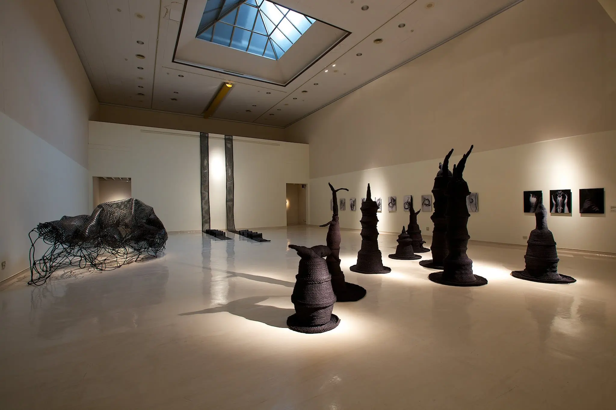 結合攝影、燈箱與黑色編織雕塑的複合裝置作品《消失前的最後嘆息》，描繪失根後的痛苦與記憶，也探索母親、獵人與分享之間的文化意象。（圖片來源／安聖惠）